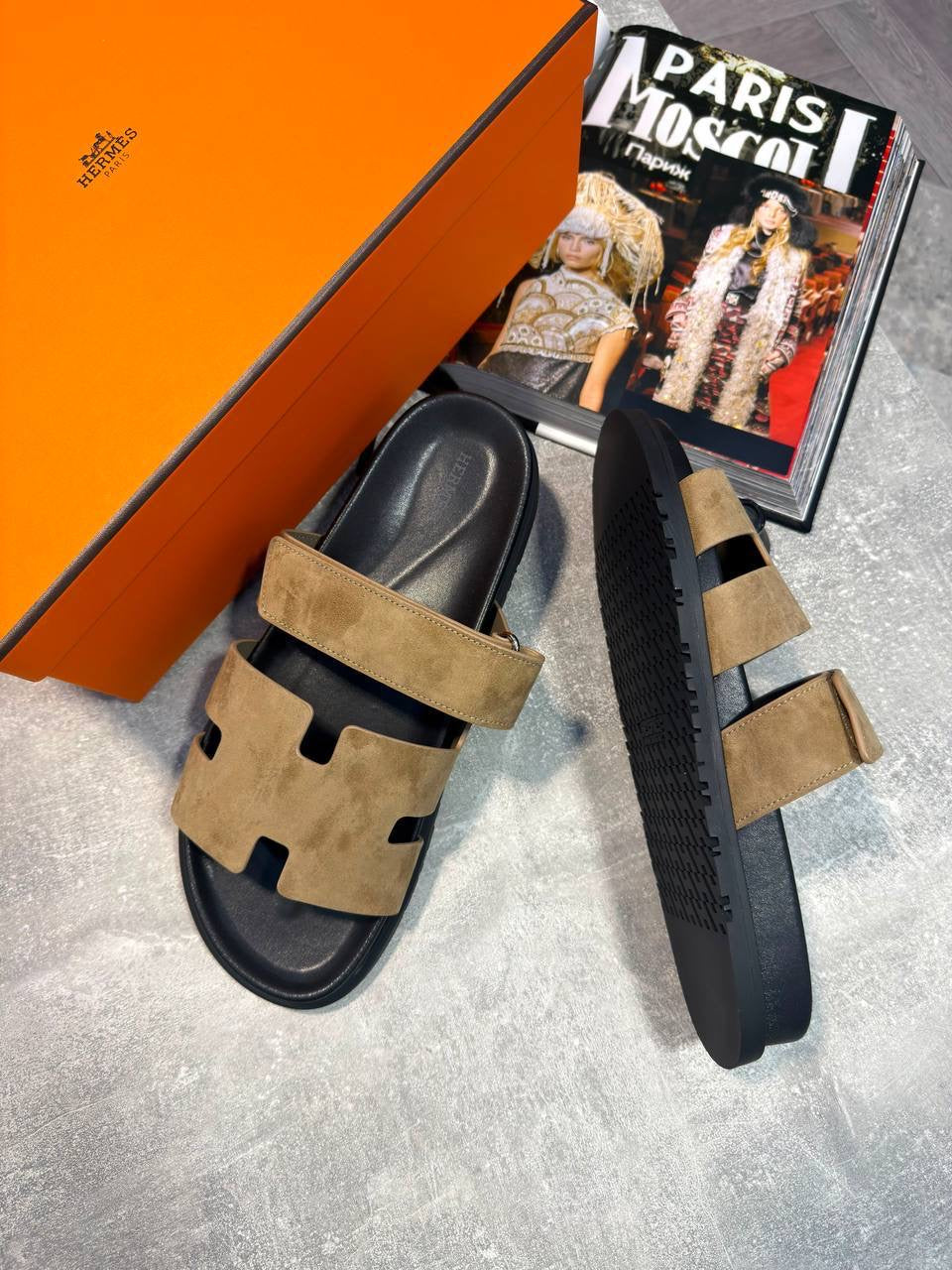 Tan suede slide sandals with black cutout straps and thick sole, side view pair