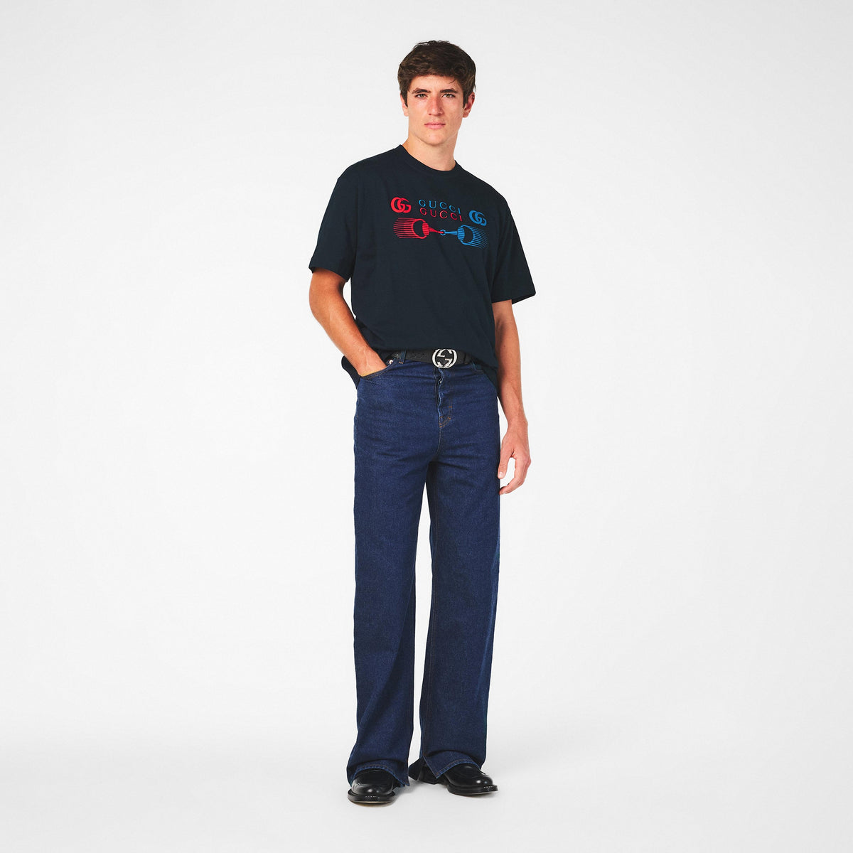 Men's dark T-shirt with small GG-logo piston print, paired with jeans on model