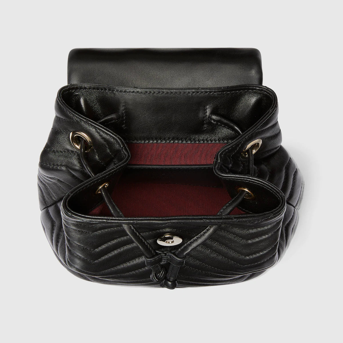 Intérieur du mini sac GG Marmont : doublure rouge et fermeture avec sangles et anneaux noirs