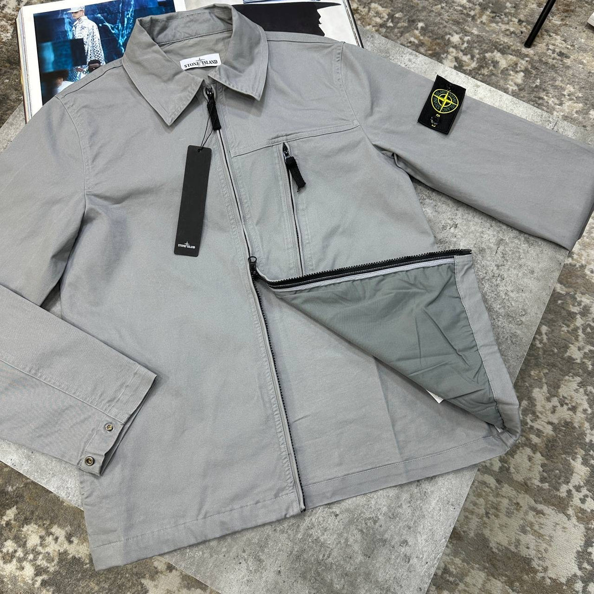 Grey overshirt jacket with zip front, pointed collar, flap pockets.