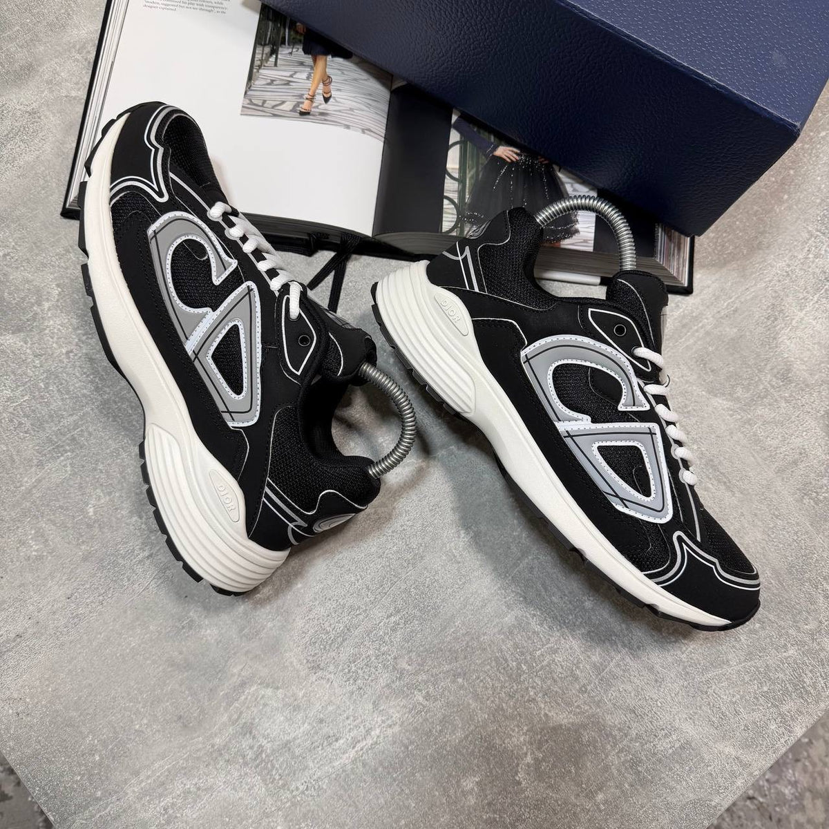 Black and white lace-up stealth sneakers with molded side panels and thick sculpted sole
