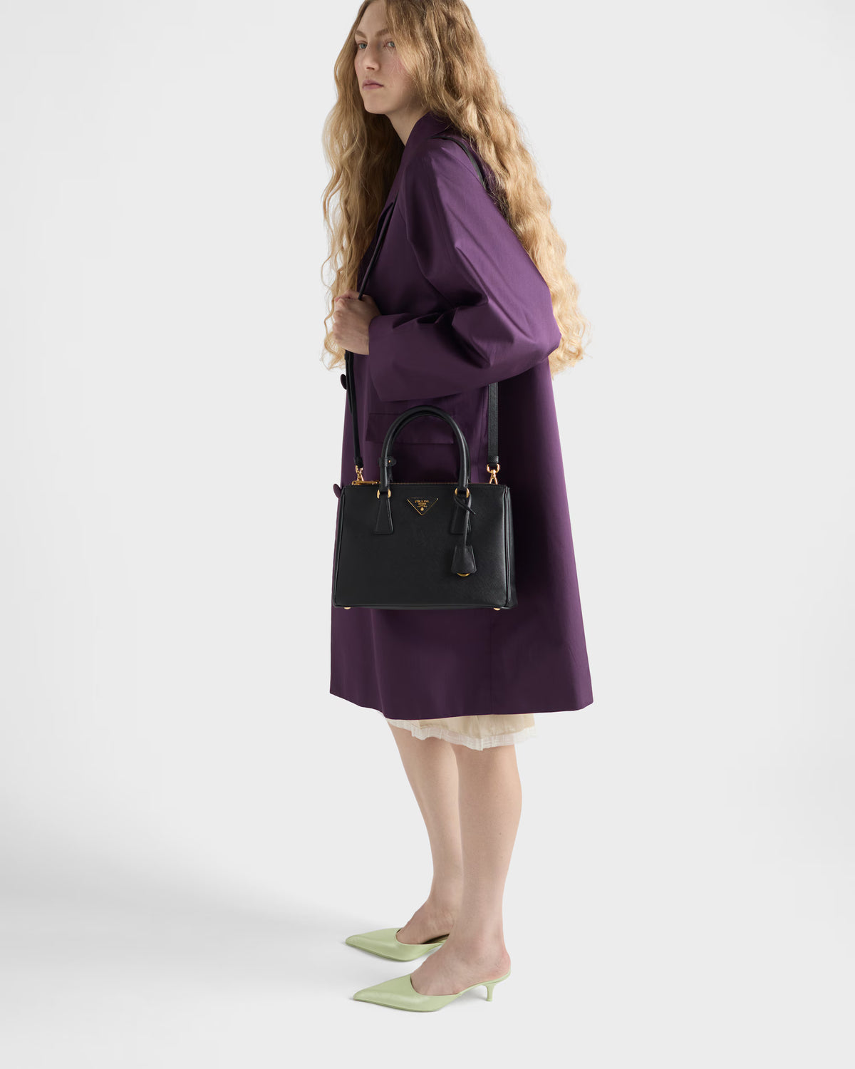Black Galleria medium Saffiano leather bag carried on shoulder with gold details