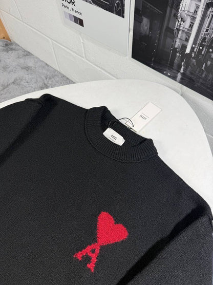 Black knit crewneck jumper with ribbed hem and cuffs, featuring a red heart emblem