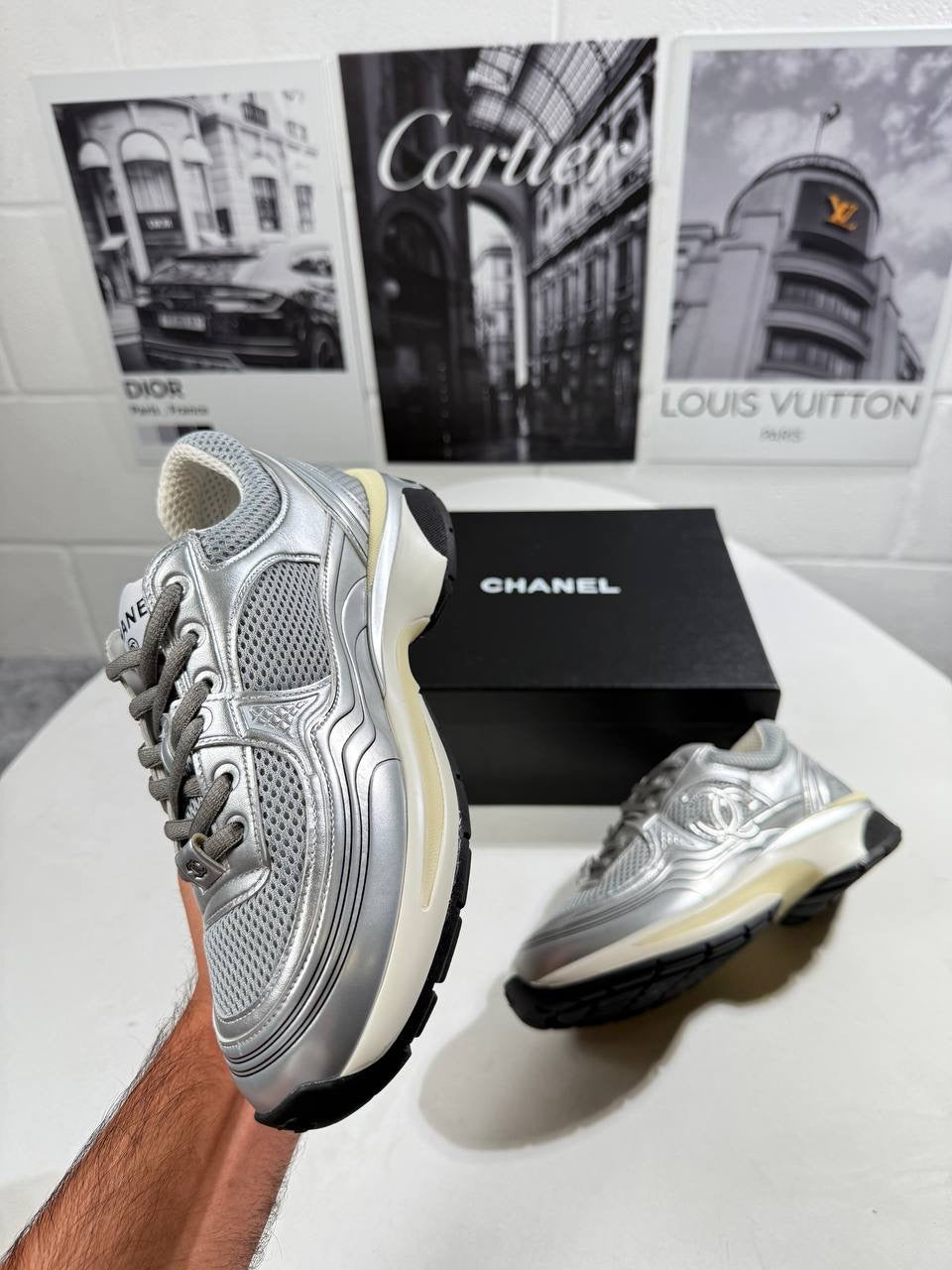 Silver lace-up trainer with mesh upper, side logo detail, black tread outsole