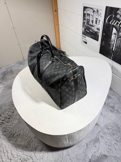 LV monogram carry bag with black handles, zip top, and adjustable shoulder strap