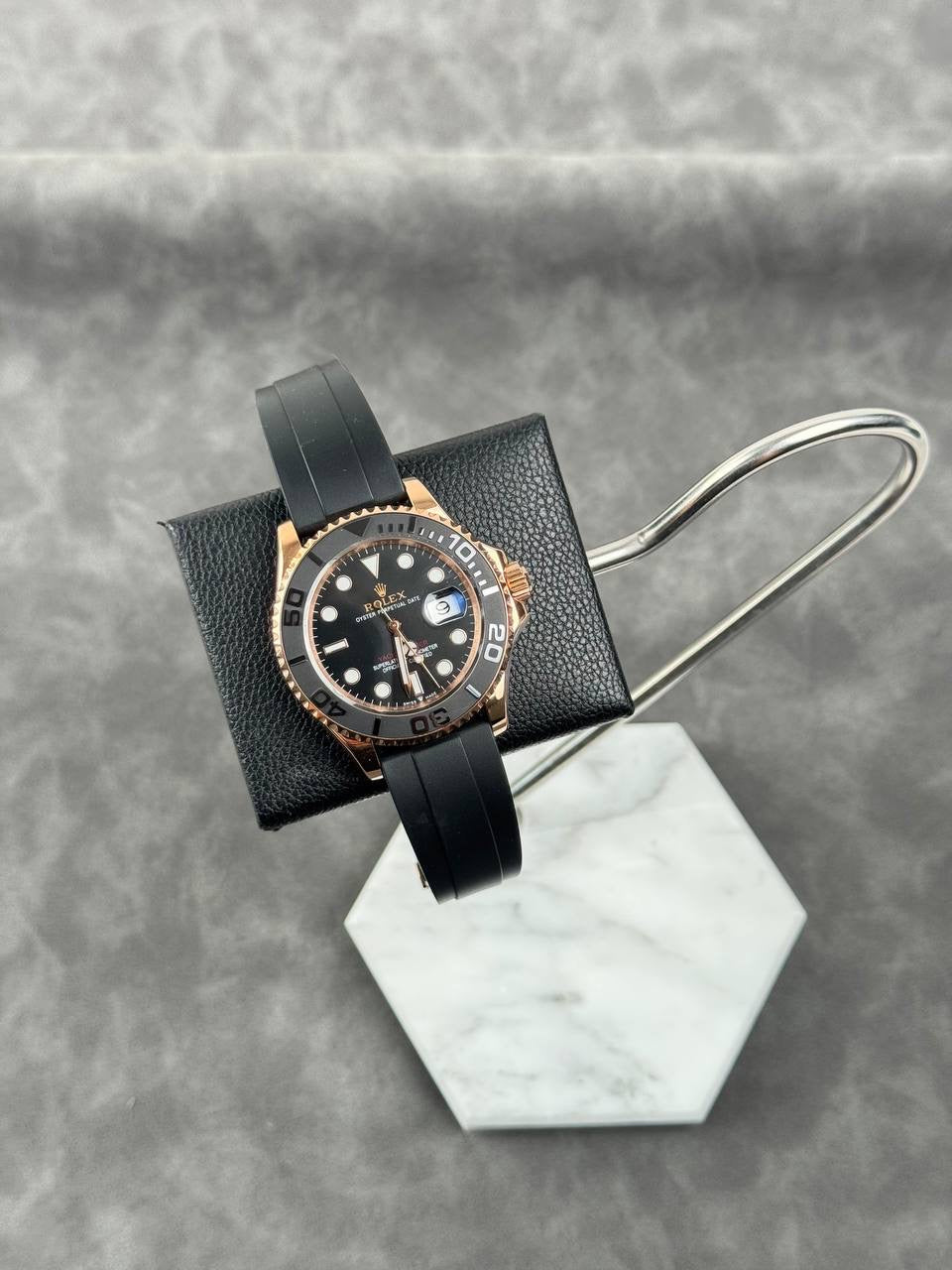 Rolex Yacht-Master style watch with black dial, rose-gold bezel, black strap