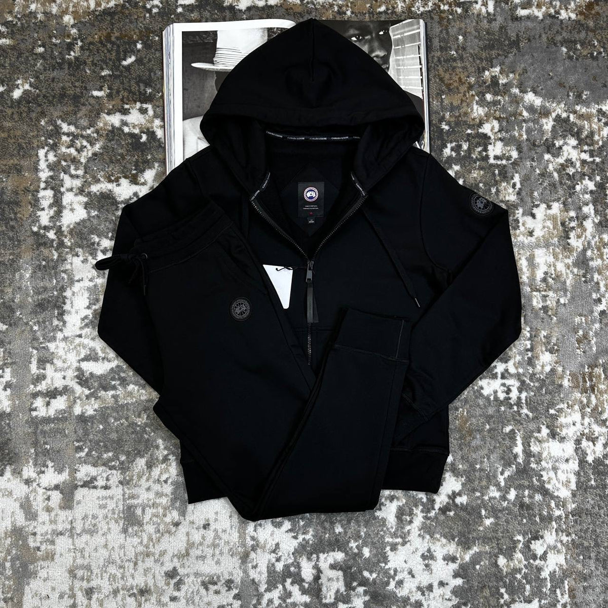 Black zip-up hooded tracksuit jacket with matching drawstring waist pants