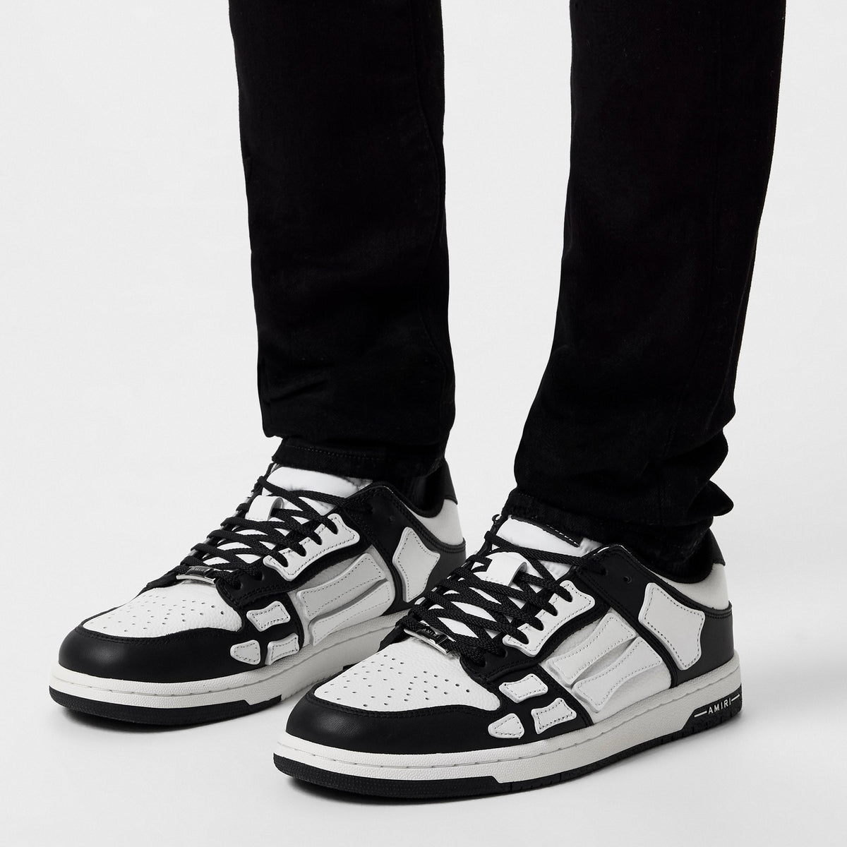Low trainers in black and white worn with dark pants