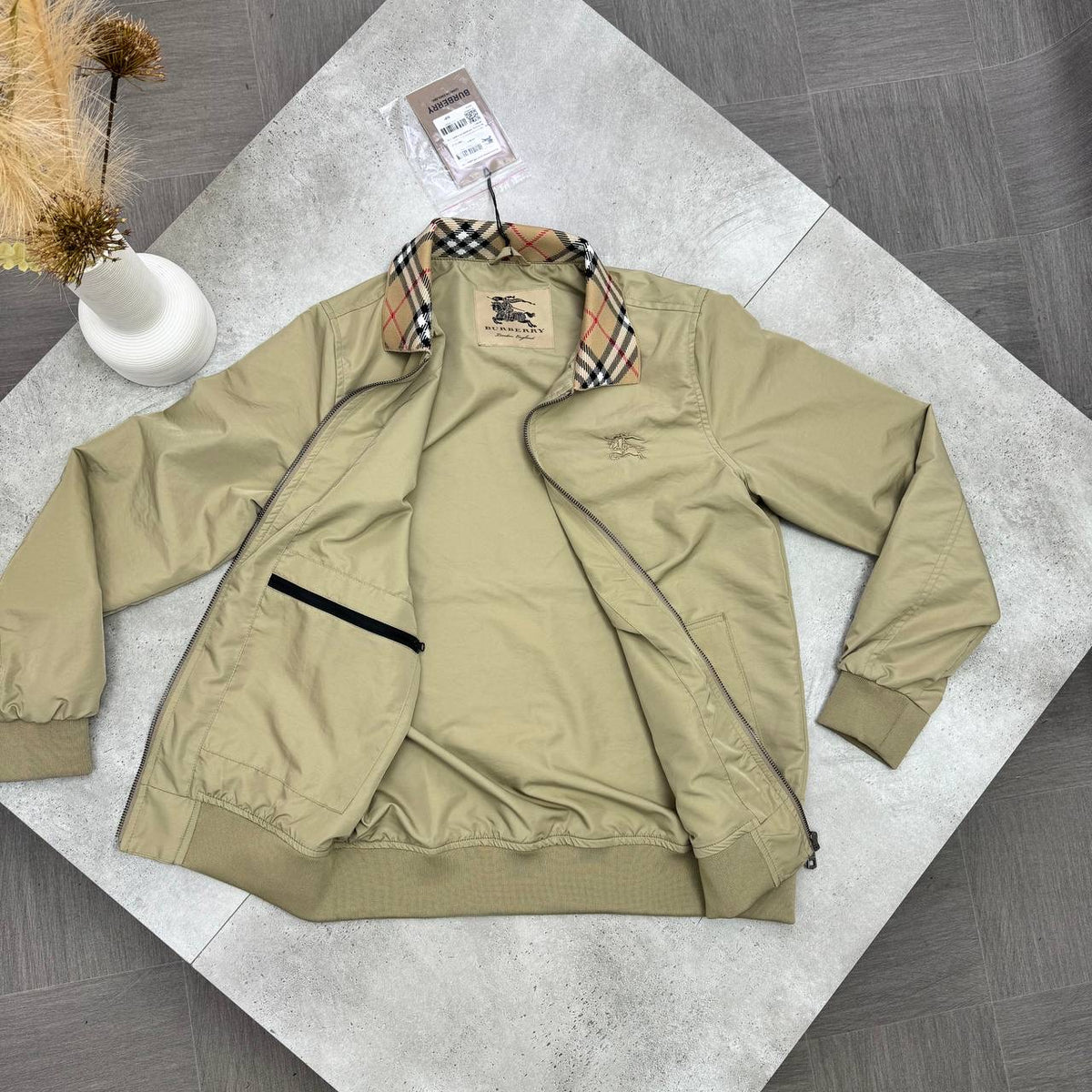 Beige jacket with plaid check-lined collar, ribbed cuffs, zip closure and pockets