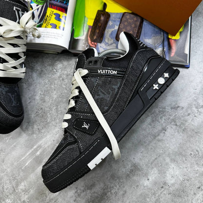 Black LV trainers with monogram panels, white laces, and chunky rubber sole.