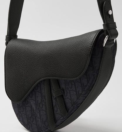 Schwarze Saddle Bag, grob genarbtes Leder mit abgerundeter Klappe und Schultergurt