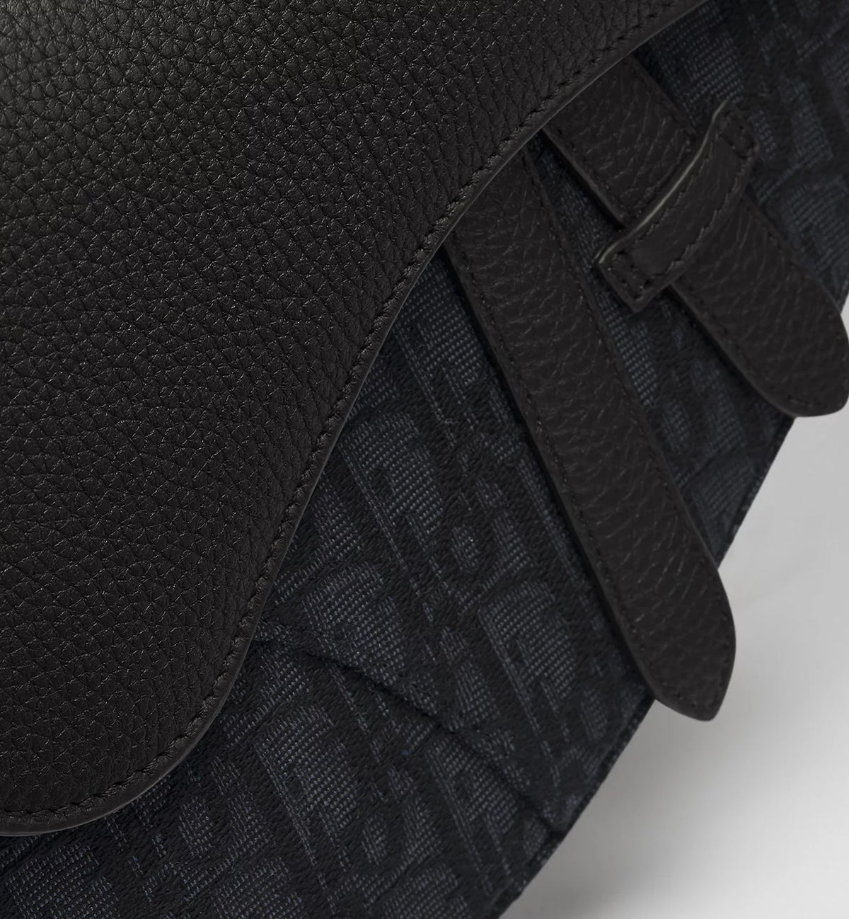 Detailansicht: schwarzer Monogramm-Einsatz auf der Saddle Bag unter der Klappe