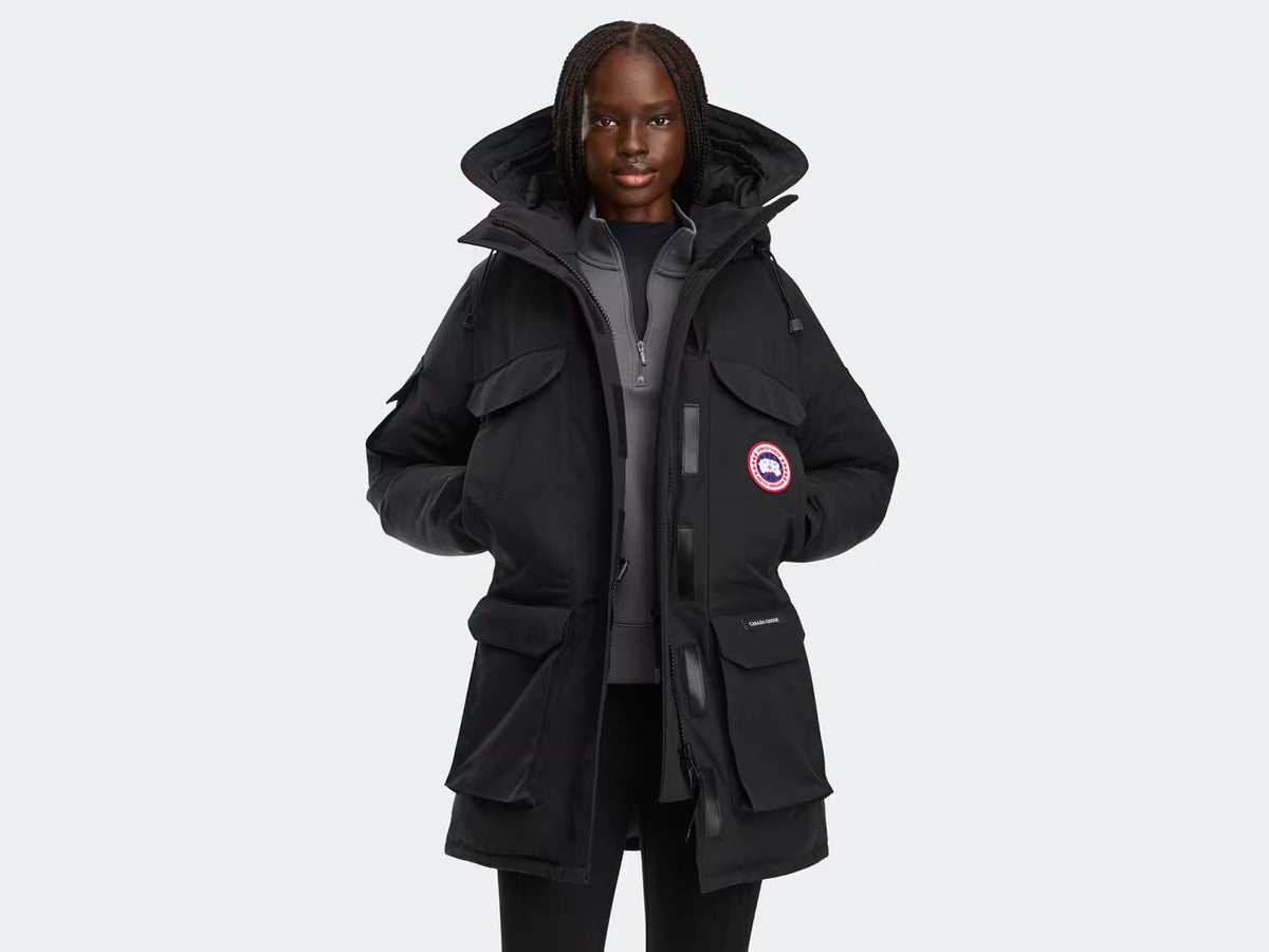 Expedition Parka femme noire à capuche, fermeture zippée, poches cargo et écusson