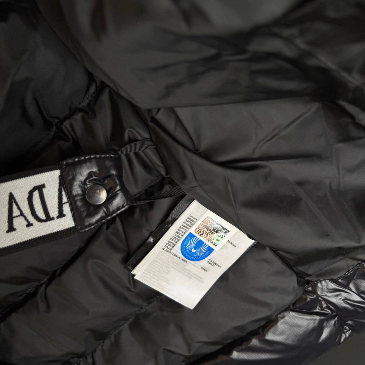 Black bubble jacket, snap collar with logo patch and hanging brand tag