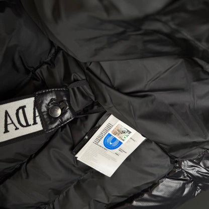 Black bubble jacket, snap collar with logo patch and hanging brand tag