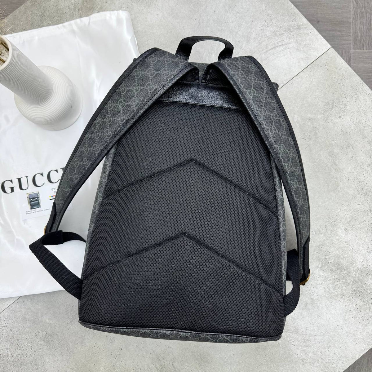 Black-and-dark-gray GG backpack with padded back panel and adjustable shoulder straps