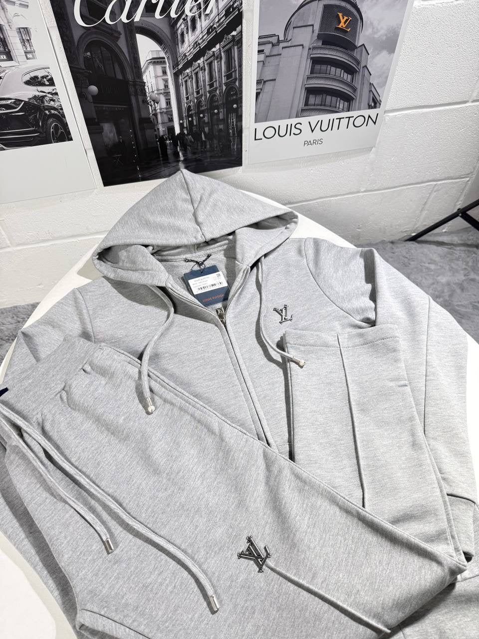 Grey tracksuit jacket with drawstring hood, front zipper, and small LV logo accents