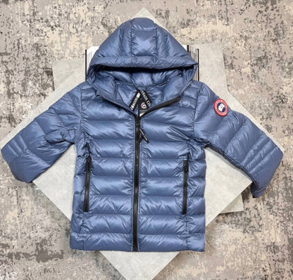 Blue hooded puffer jacket with full-zip front, drawstring hood, and red sleeve badge
