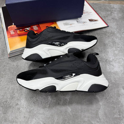Black low-top trainers with chunky white sole, lace-up, perforated and mesh panels