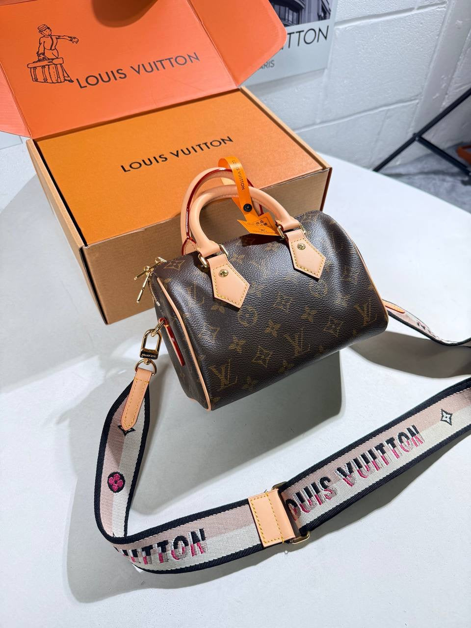 Louis Vuitton nano Speedy bag with monogram canvas, tan leather handles, and patterned crossbody strap