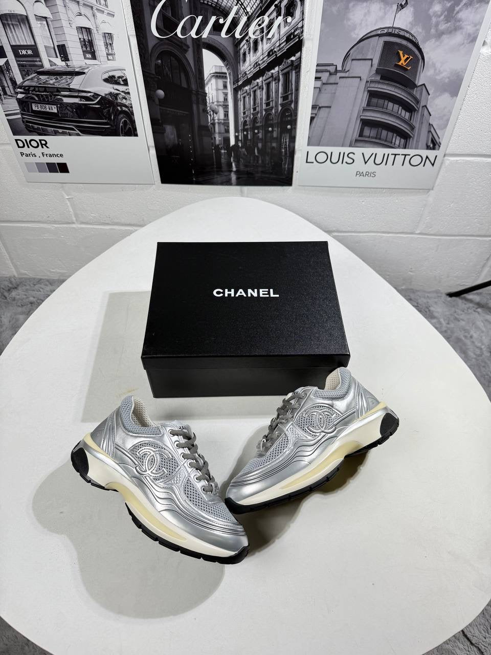 Silver trainers pair with mesh uppers, black trim, and cream-tinted sole accents