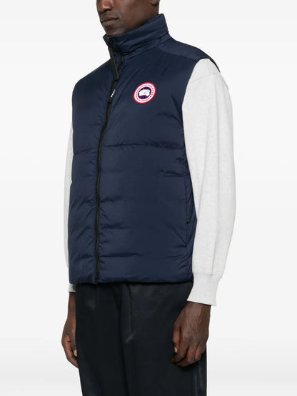 Navy quilted gilet with logo patch; zip front and padded insulated panels