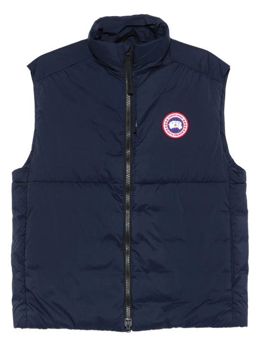 Navy quilted gilet with full-zip front and circular logo patch on chest
