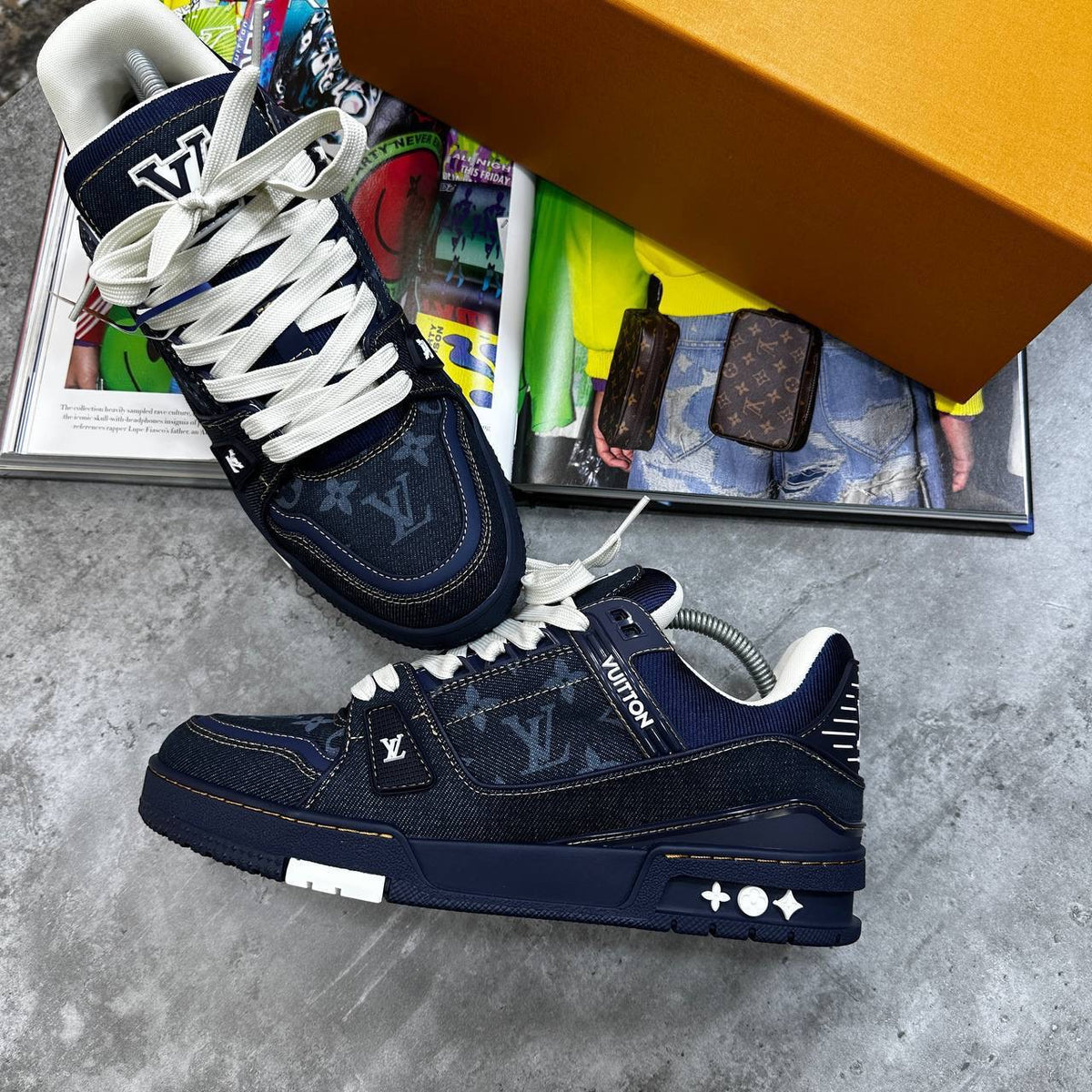 Navy LV trainers with monogram fabric, white laces, and star detail on side.