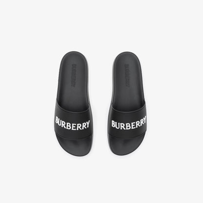 Schwarze Slides mit eingeprägtem BURBERRY-Schriftzug an der Fußfläche