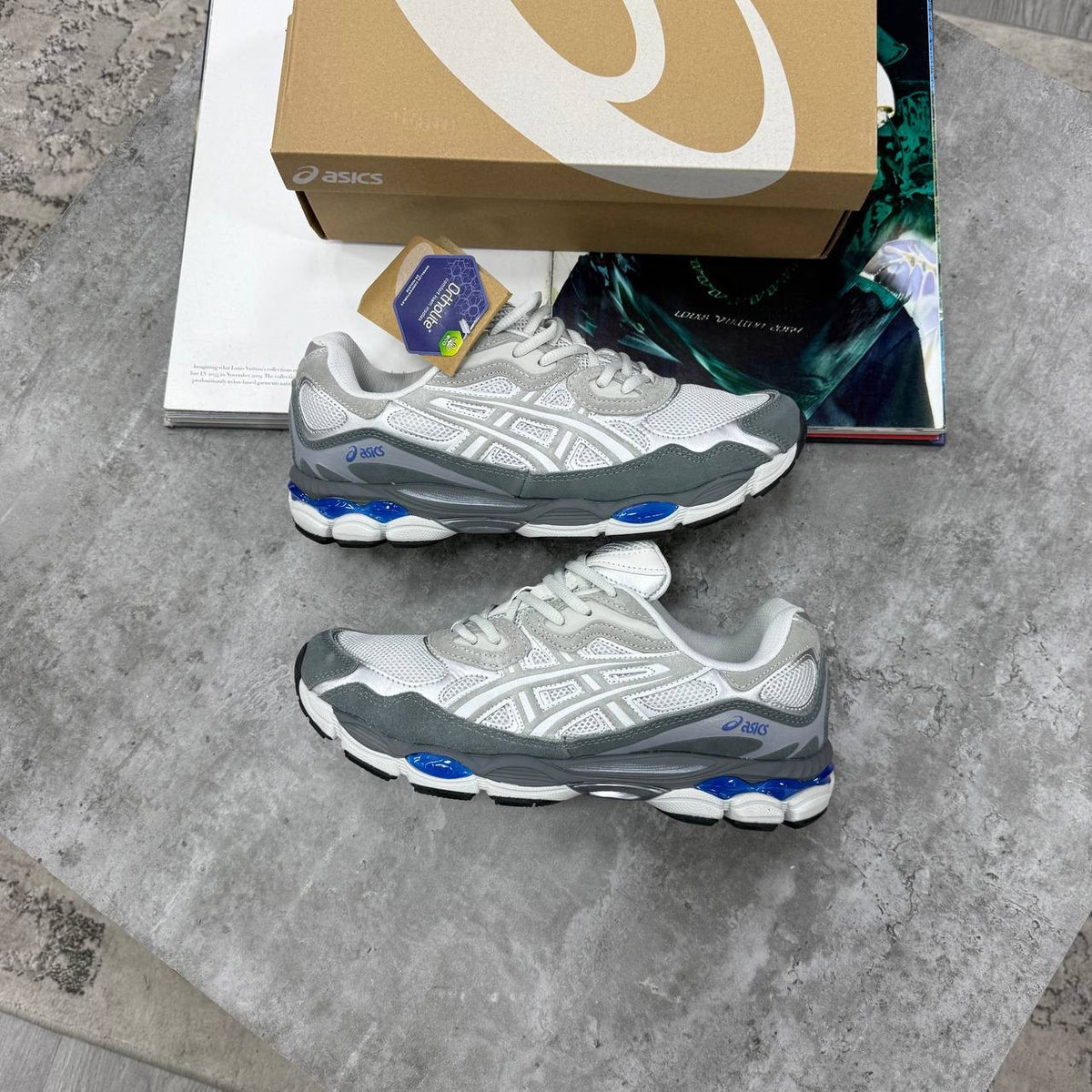 ASICS running shoes in light gray with bright blue accents on the outsole