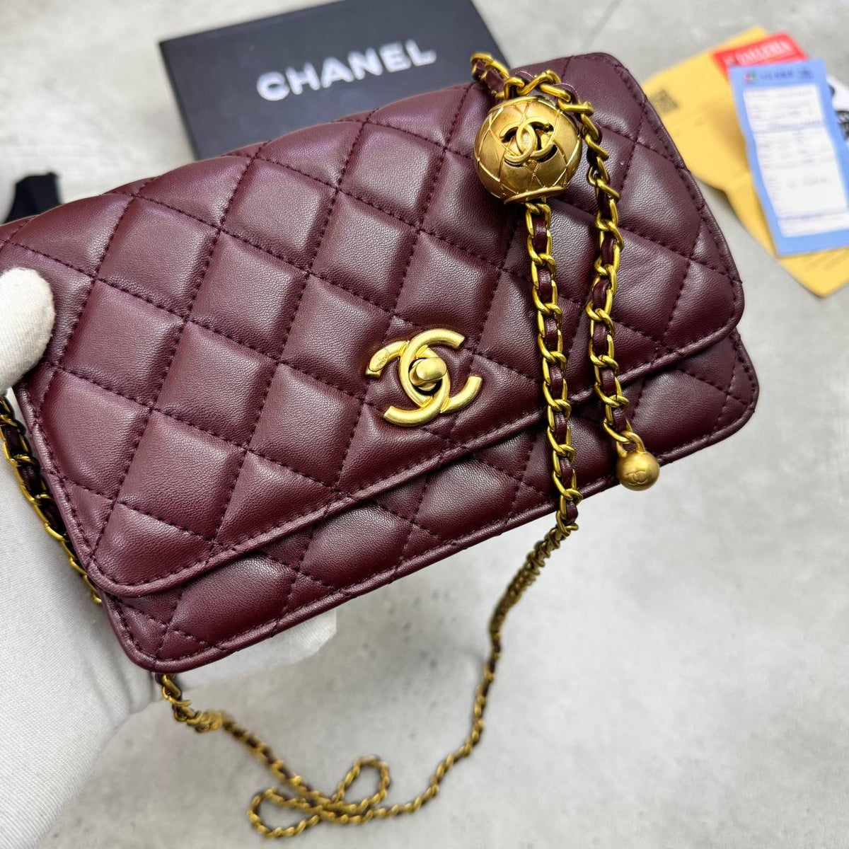 Burgundy quilted flap bag with gold-tone CC emblem and chain shoulder strap