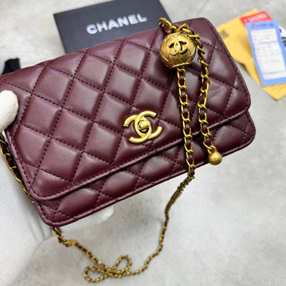 Burgundy quilted flap bag with gold-tone CC emblem and chain shoulder strap