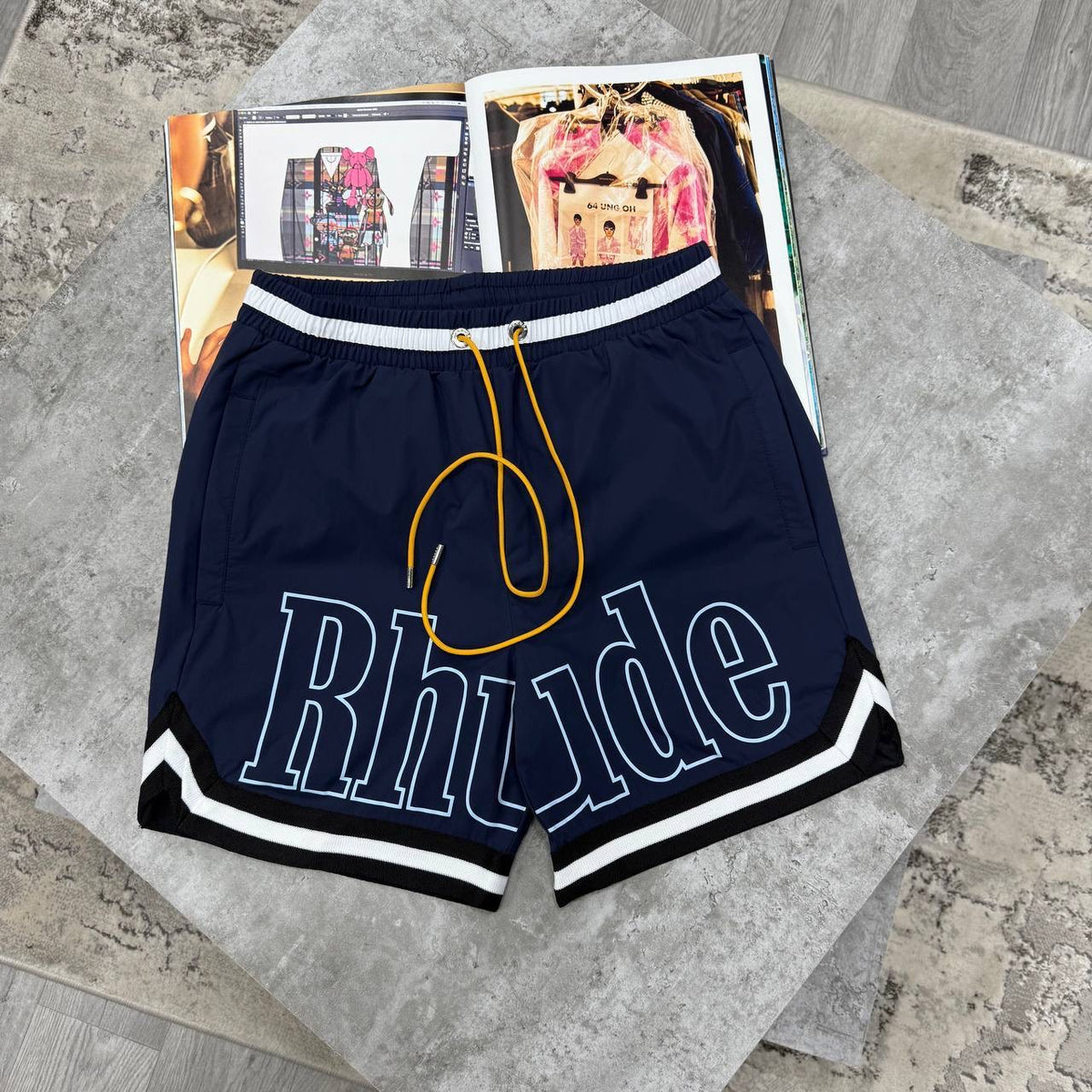 Rhude navy drawstring shorts with elastic waist and white striped hem