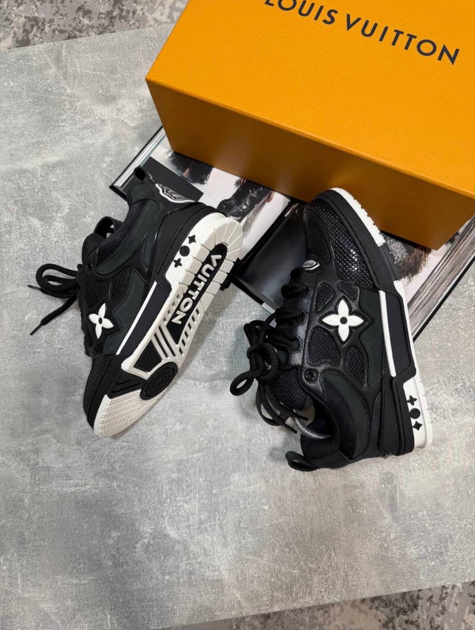 Black skate sneakers with black laces, logo flower emblems, chunky sole with white trim