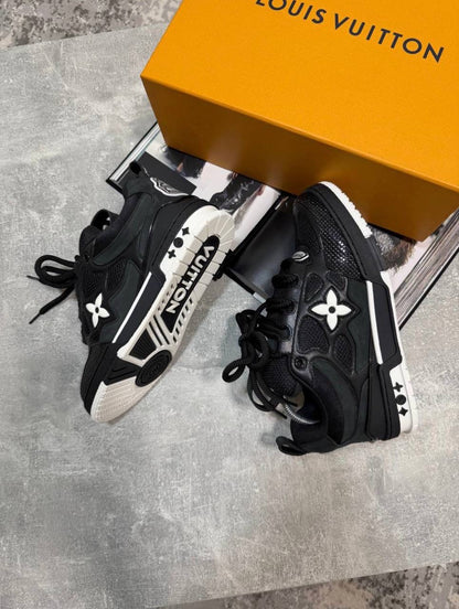 Black skate sneakers with black laces, logo flower emblems, chunky sole with white trim
