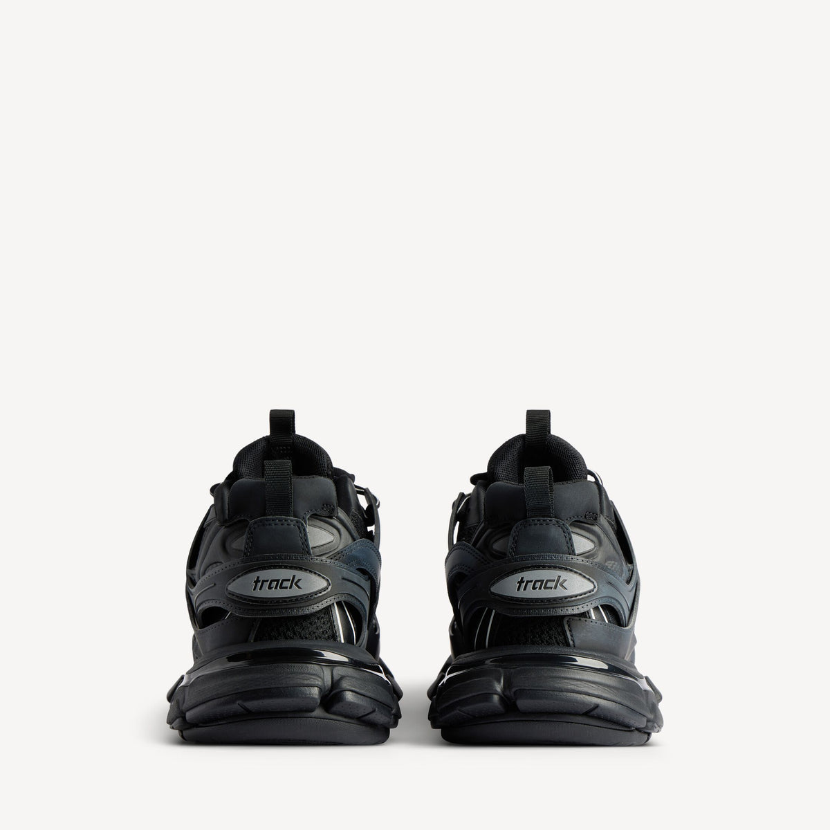 Men's black track sneaker, heel view with 'track' logo tab and thick cushioning