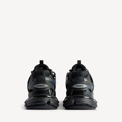 Men's black track sneaker, heel view with 'track' logo tab and thick cushioning