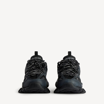 Men's black track sneaker, front view with lace loops and toe mesh panels