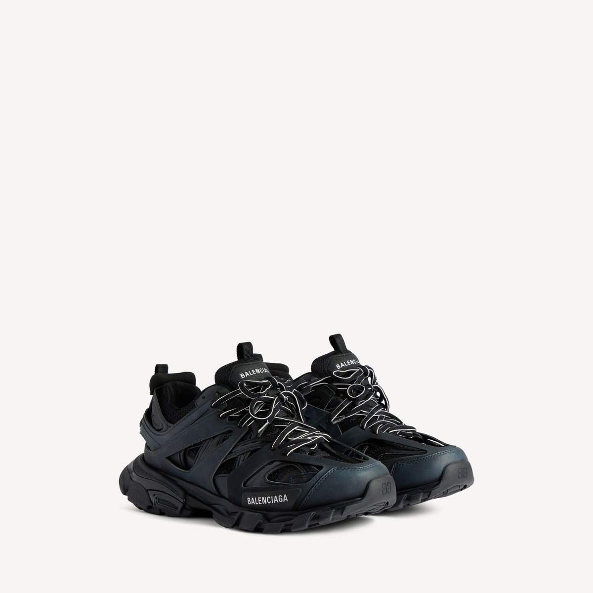 Men's black track sneaker, side profile view with rugged outsole tread