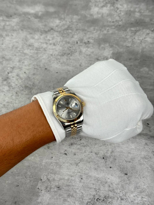 Rolex two-tone watch with silver dial on white sleeve cuff, metal bracelet