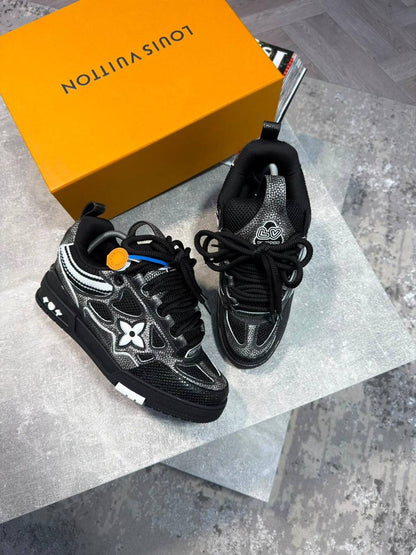 Black skate sneakers with black laces, silver logo flower emblems, chunky sole