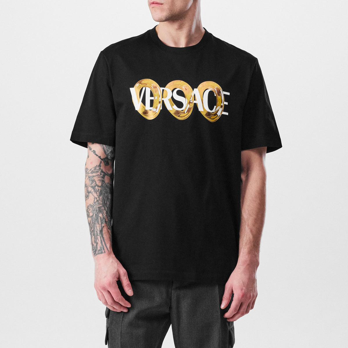 Black T-shirt with gold Versace ring logo print across the chest
