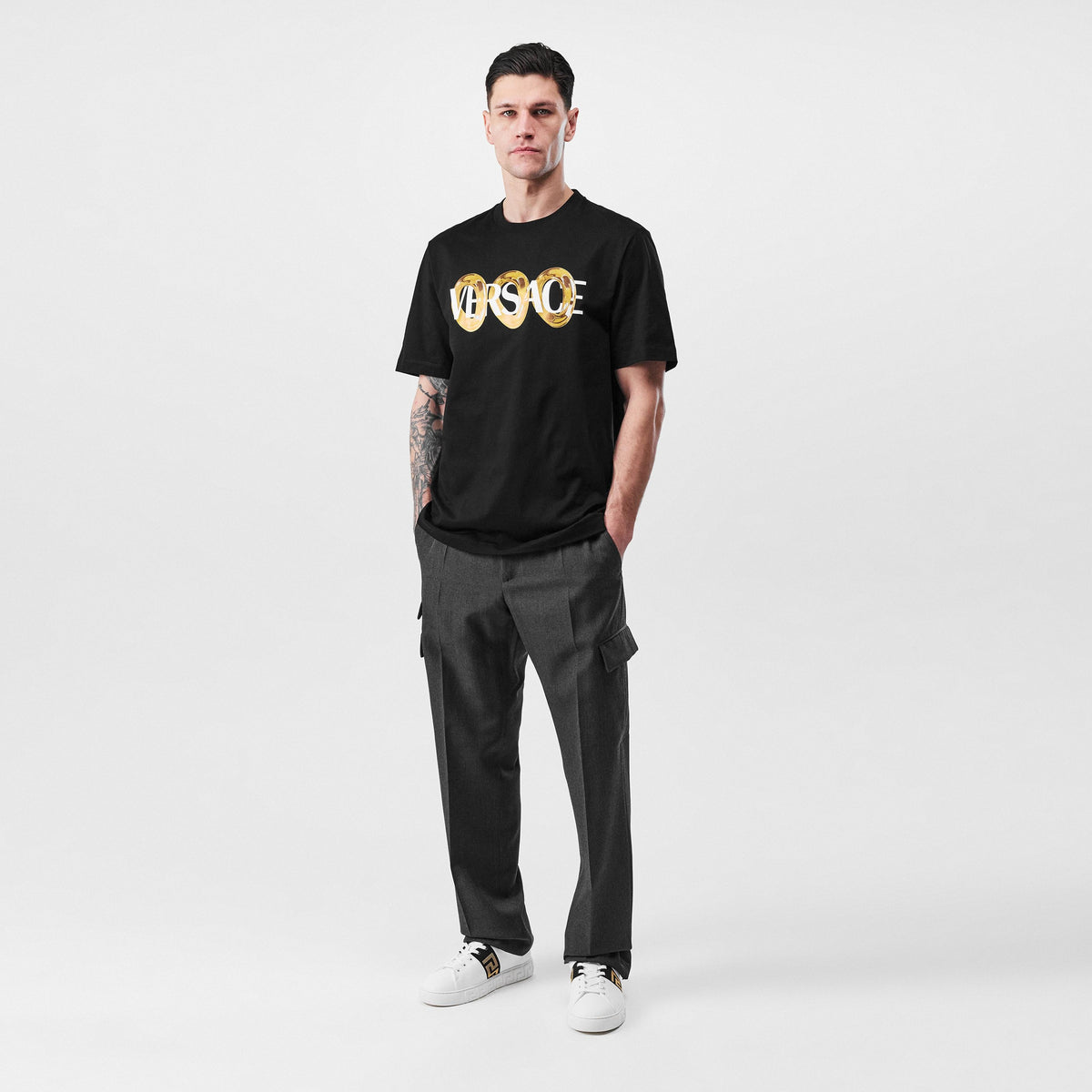 Black crewneck T-shirt featuring a gold Versace ring graphic on the front
