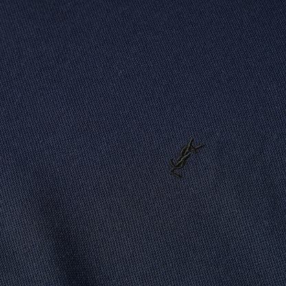 Close-up of navy knit T-shirt fabric with small embroidered logo