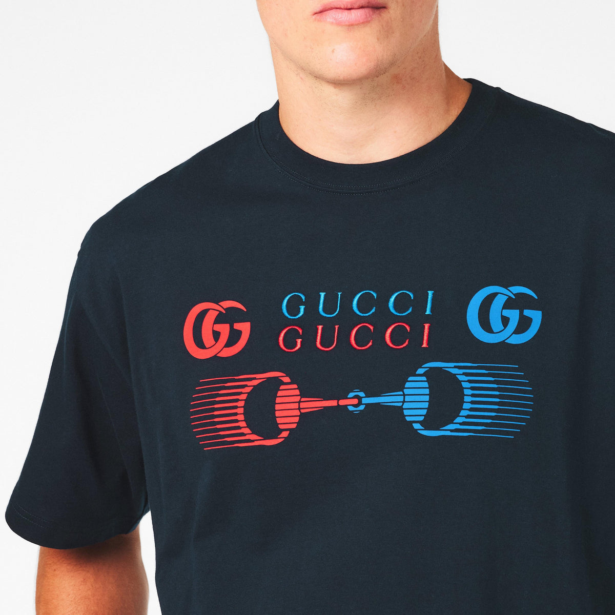 Close-up: dark T-shirt with colorful GG logo and blue/red piston graphic