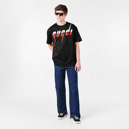 Schwarzes T-Shirt am Modell mit „gucci!“ Print in Weiß und Rot