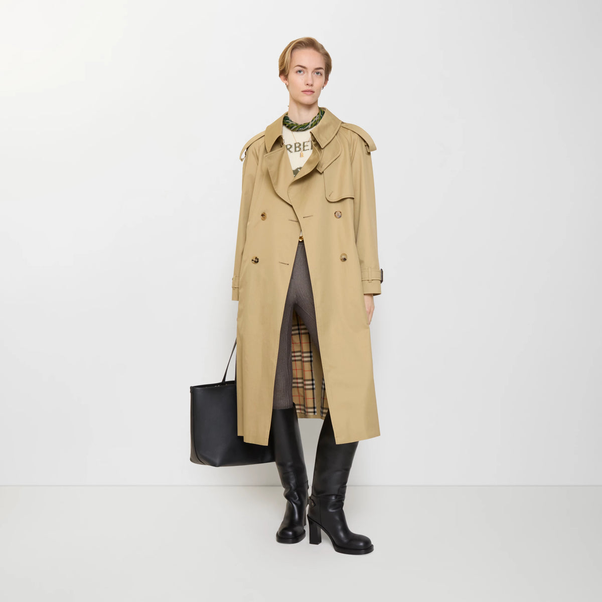 Long gabardine trench coat, tan color, open lapels with belt buckle and side pockets