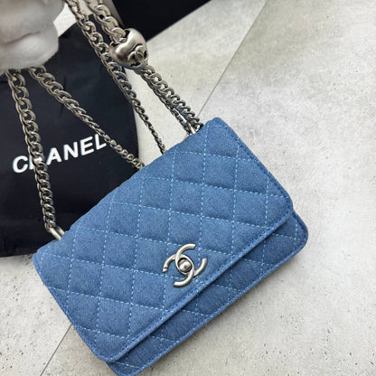 Blue quilted denim flap bag with silver chain strap and C-shaped logo clasp