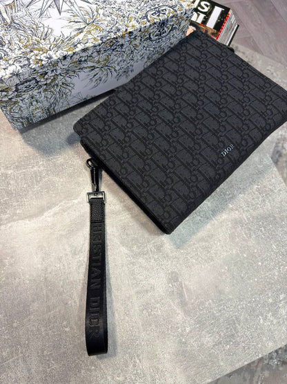 Black Dior Oblique pouch with zip closure, flat wrist strap, textured monogram front