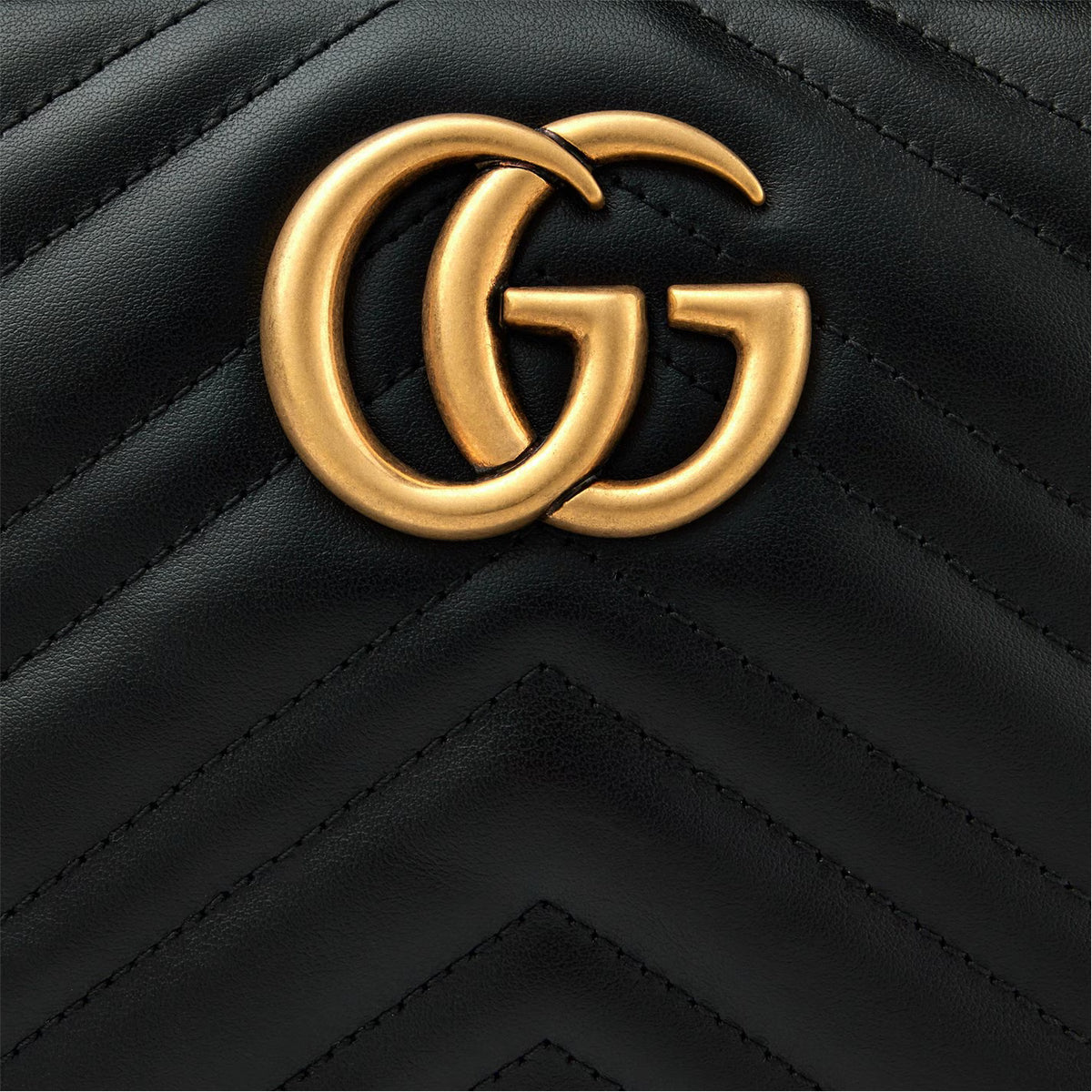Gold-tone GG logo on black quilted leather with chevron stitching.